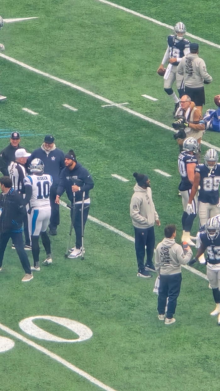 Dak Prescott on field with crutches