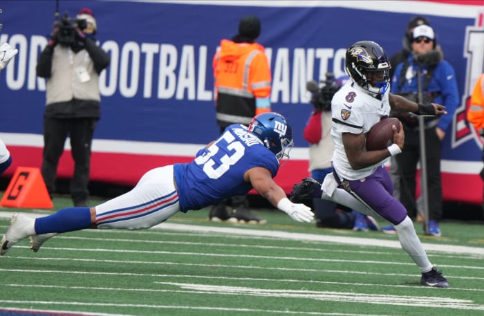 East Rutherford, NJ -- December 15, 2024 -- Darius Muasau of the Giants tries to tackle Lamar Jackson of the Ravens in the first half. The Baltimore Ravens came to MetLife Stadium to play the New York Giants.