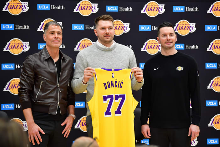 Los Angeles Lakers guard Luka Doncic poses for photos with general manager Rob Pelinka and head coach JJ Redick.