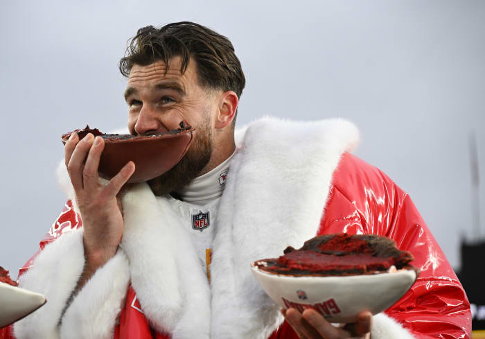 Kansas City Chiefs tight end Travis Kelce eats a football cake.