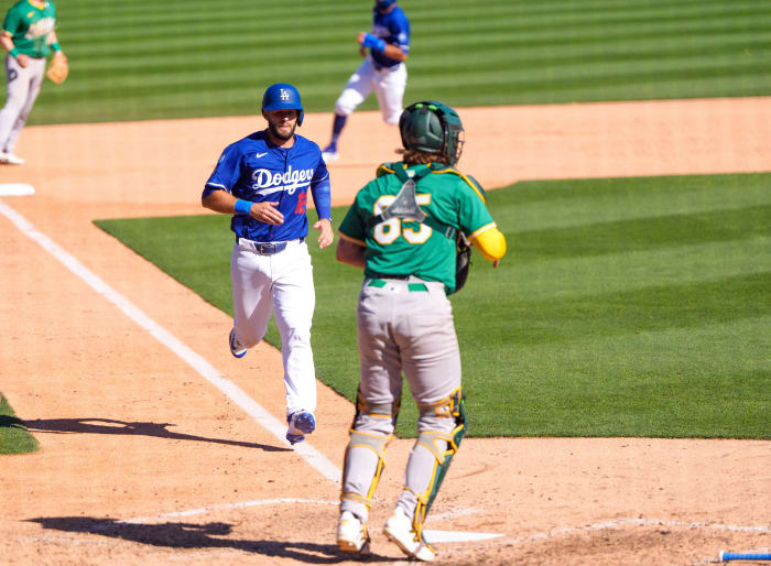 Mar 9, 2025; Los Angeles Dodgers infielder David Bote (12) comes in to score as Oakland Athletics catcher Willie MacIver (65) awaits the throw home.