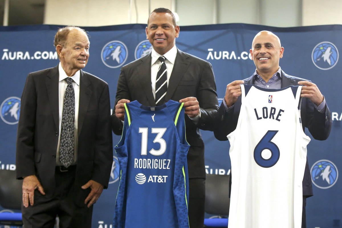 Sep 27, 2021; Minneapolis, MN, USA; Current owner Glen Taylor and limited partners and alt-governors for the Minnesota Timberwolves Alex Rodriguez and Mark Lore hold up jerseys after answering questions at a press conference at media day.