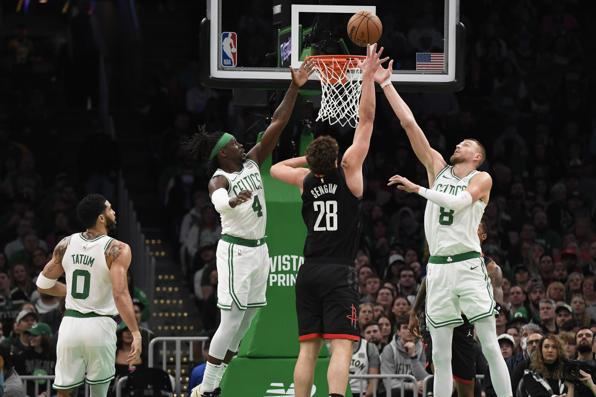 Jan 13, 2024; Boston, Massachusetts, USA; Boston Celtics guard Jrue Holiday (4) and center Kristaps Porzingis (8) and Houston Rockets center Alperen Sengun (28) battle for a rebound during the first half at TD Garden.