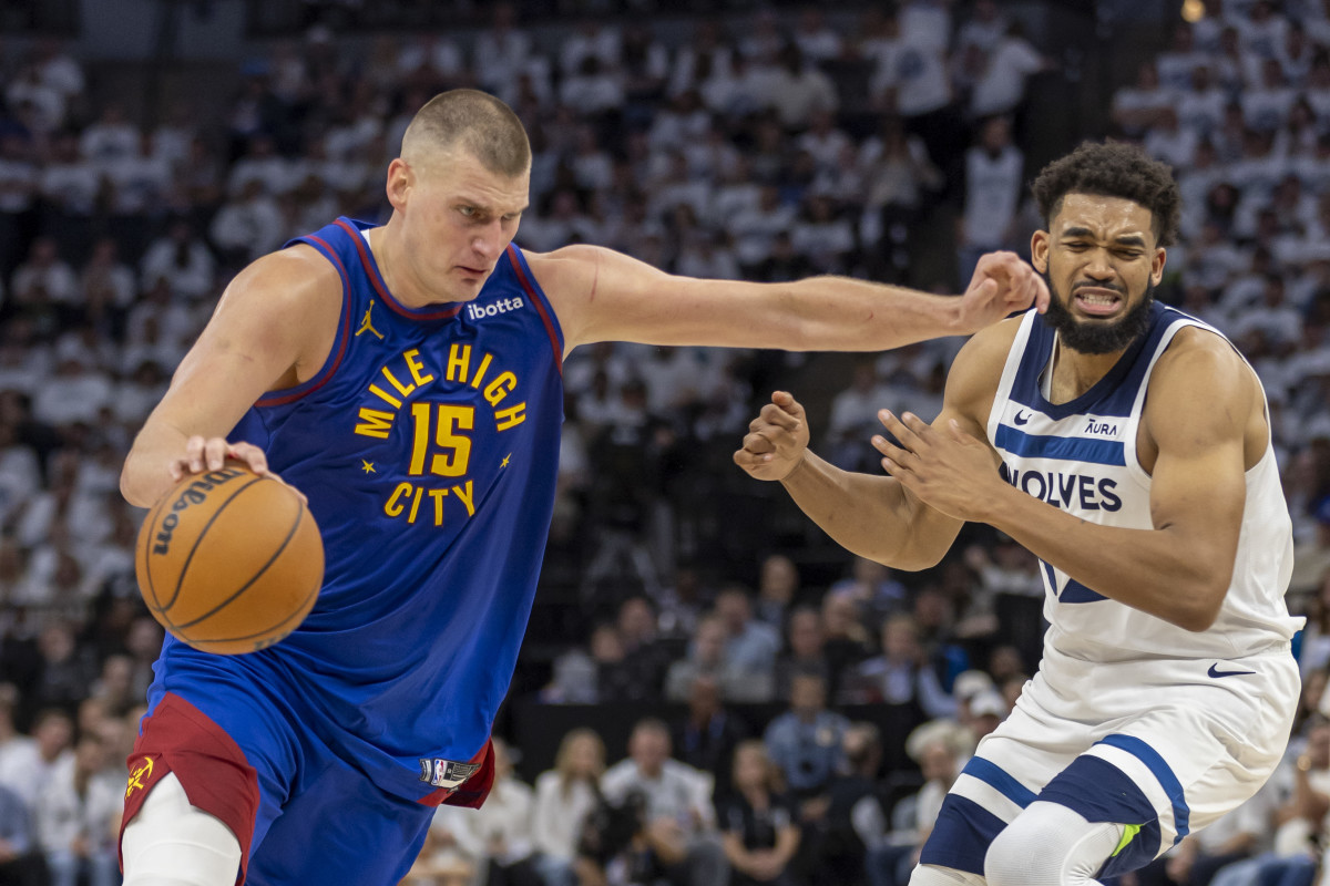 Denver Nuggets center Nikola Jokic (15) drives to the basket past Minnesota Timberwolves center Karl-Anthony Towns (32) in the first half