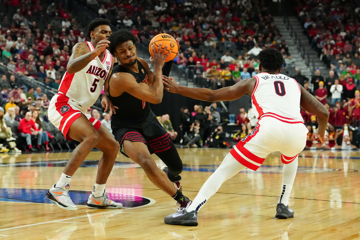 Southern California Trojans guard Bronny James (6) drives the lane between Arizona Wildcats guard KJ Lewis (5) and guard Jaden Bradley (0) during the first half at T-Mobile Arena.