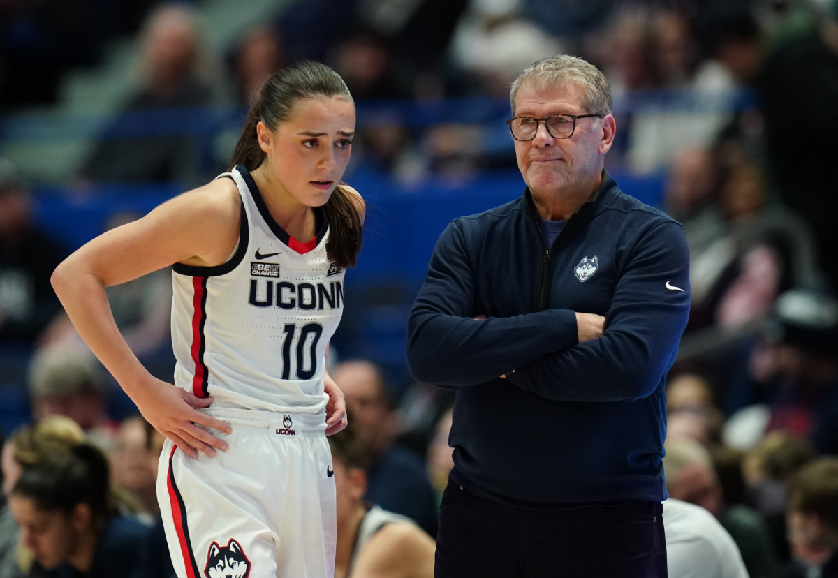 UConn Huskies head coach Geno Auriemma talks with guard Nika Muhl (10) from the sideline as they take on the Georgetown Hoyas at XL Center.