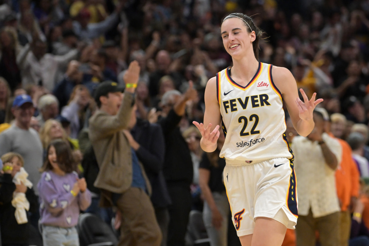 Indiana Fever guard Caitlin Clark (22) smiles as she heads down court after a 3-point basket in the final seconds of the game against the Los Angeles Sparks at Crypto.com Arena.