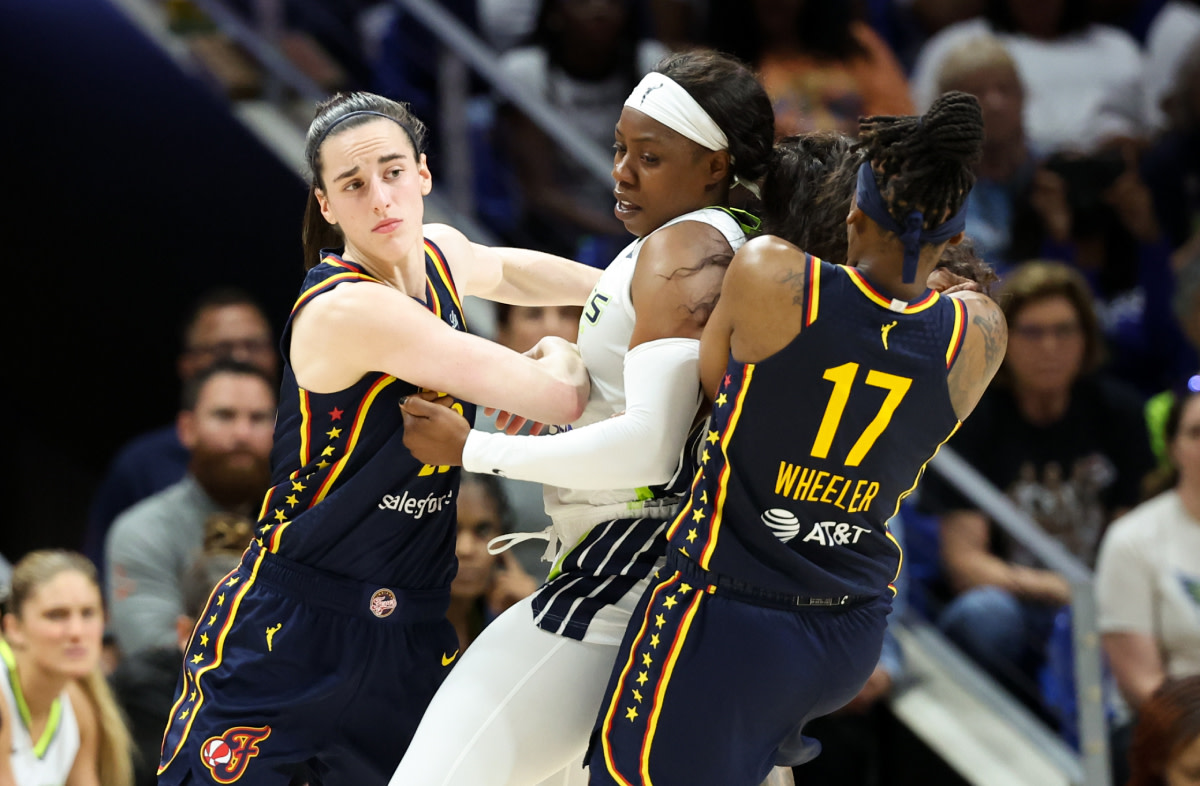 Indiana Fever guard Caitlin Clark (22) looks to break free from Dallas Wings guard Arike Ogunbowale (24) as Indiana Fever guard Erica Wheeler (17) sets a screen during the second half at College Park Center.