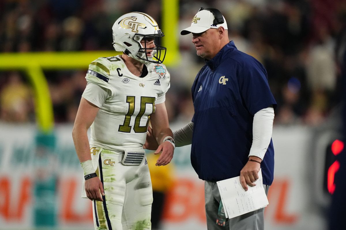 Georgia Tech Yellow Jackets head coach Brent Key speaks with quarterback Haynes King.