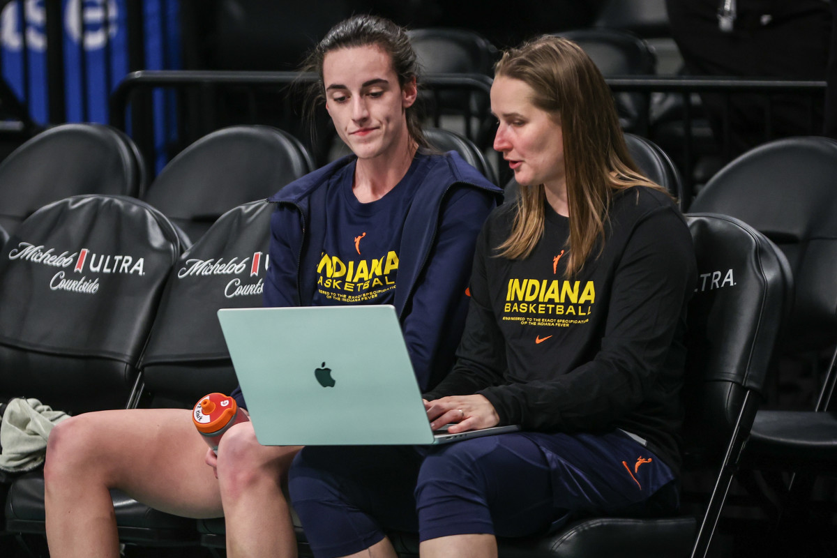 Indiana Fever guard Caitlin Clark (22) talks with assistant coach Jessie Miller