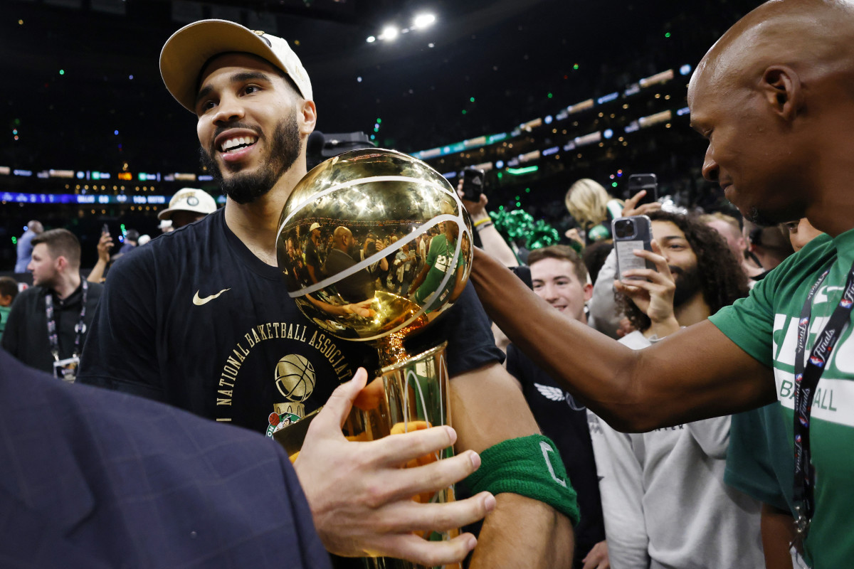 Boston Celtics forward Jayson Tatum (0) is greeted by Ray Allen as he walks off the court with the trophy as he celebrates winning the 2024 NBA Finals against the Dallas Mavericks at TD Garden.