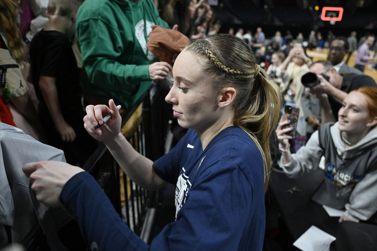 Apr 1, 2024; Portland, OR, USA; UConn Huskies guard Paige Bueckers (5) signs autographs for fans after a game against the USC Trojans in the finals of the Portland Regional of the NCAA Tournament at the Moda Center.