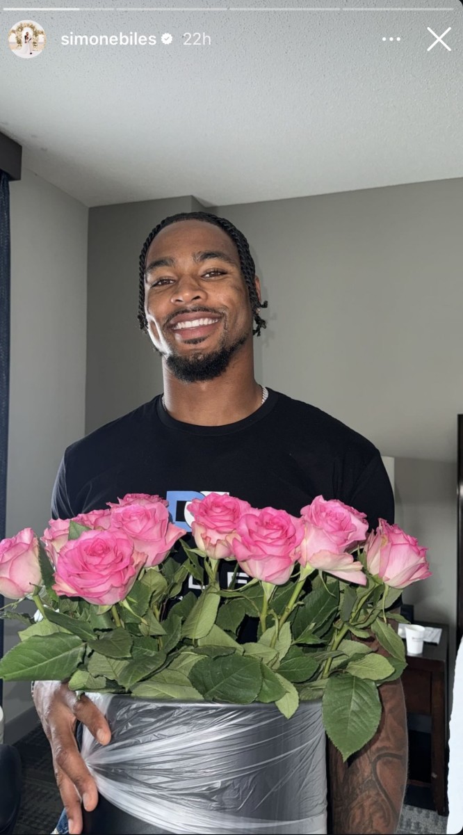 Simone Biles receivers a bouquet of flowers from her husband, Jonathan Owens.