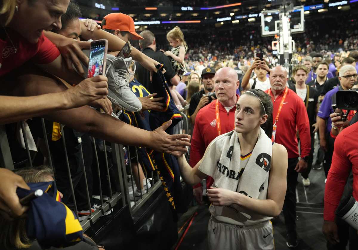 Indiana Fever guard Caitlin Clark (22) signs autographs for fans.