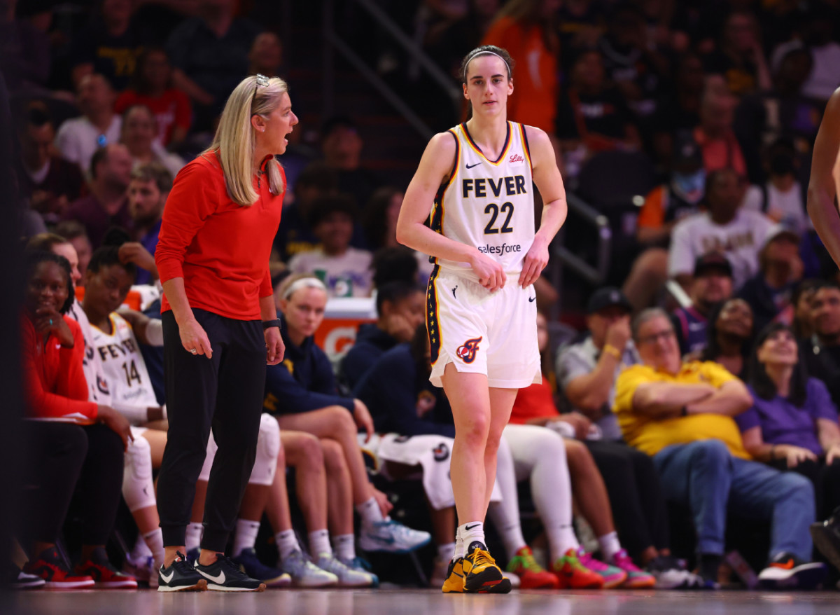 Indiana Fever head coach Christie Sides speaks to guard Caitlin Clark during their game against the Phoenix Mercury on June 30 at Footprint Center.