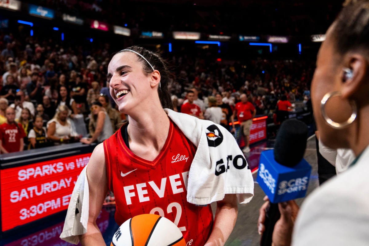 Indiana Fever guard Caitlin Clark (22) smiles in an interview after becoming the first rookie to have a triple-double during a game against the New York Liberty at Gainbridge Fieldhouse.