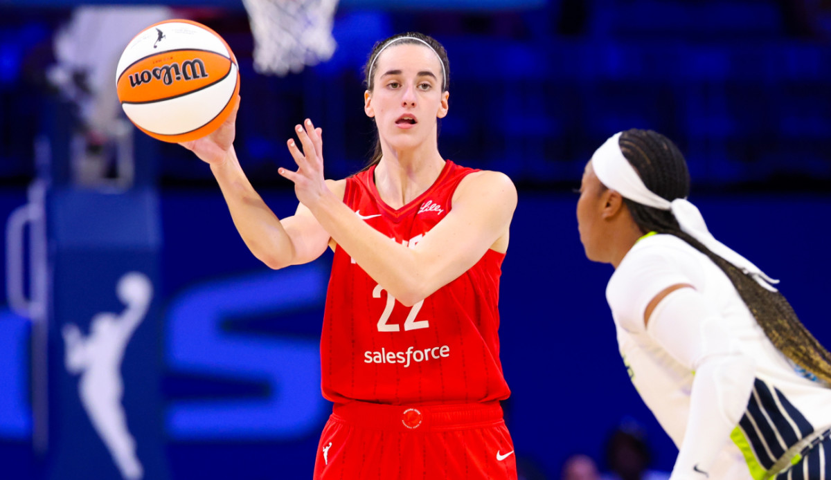 Indiana Fever guard Caitlin Clark (22) passes the ball past Dallas Wings guard Odyssey Sims (2) during the second half at College Park Center.