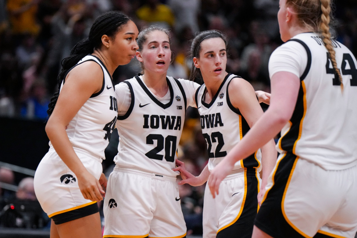 Iowa Hawkeyes forward Hannah Stuelke, left, guard Kate Martin, middle, and guard Caitlin Clark huddle during a stop in play against the LSU Lady Tigers in the first half during the final round of the Women's Final Four NCAA tournament at the American Airlines Center.