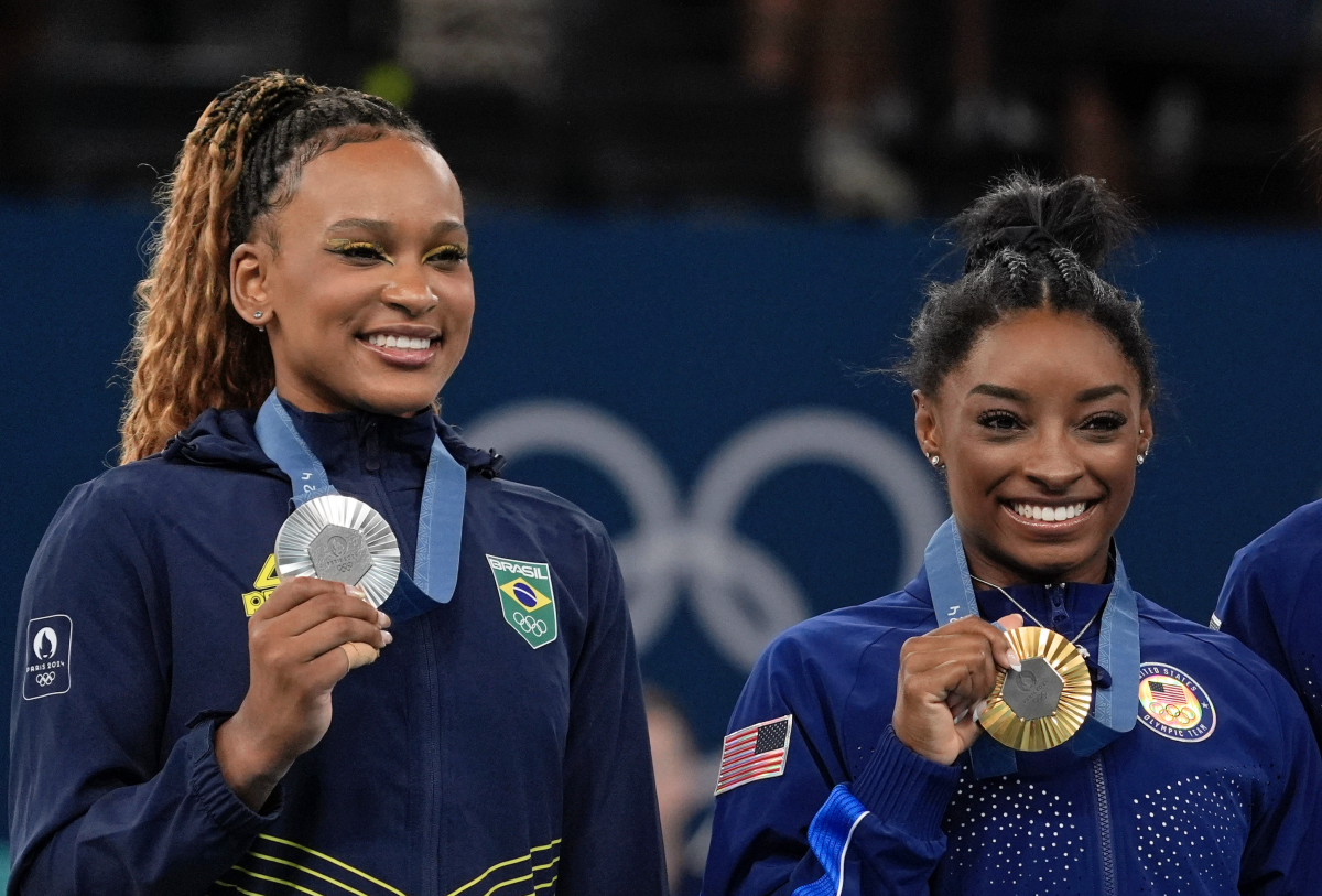 Rebeca Andrade of Brazil and Simone Biles of the United States pose for a photo with their medals in the women's gymnastics all-around during the Paris 2024 Olympic Summer Games at Bercy Arena.