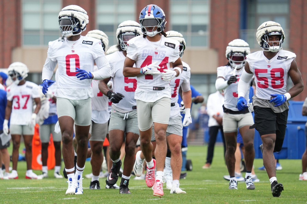 Jul 25, 2024; East Rutherford, NY, USA; New York Giants linebacker Brian Burns (0), cornerback Nick McCloud (44) and inside linebacker Bobby Okereke (58) take the field during training camp at Quest Diagnostics Training Center. Mandatory Credit: Lucas Boland-USA TODAY Sports