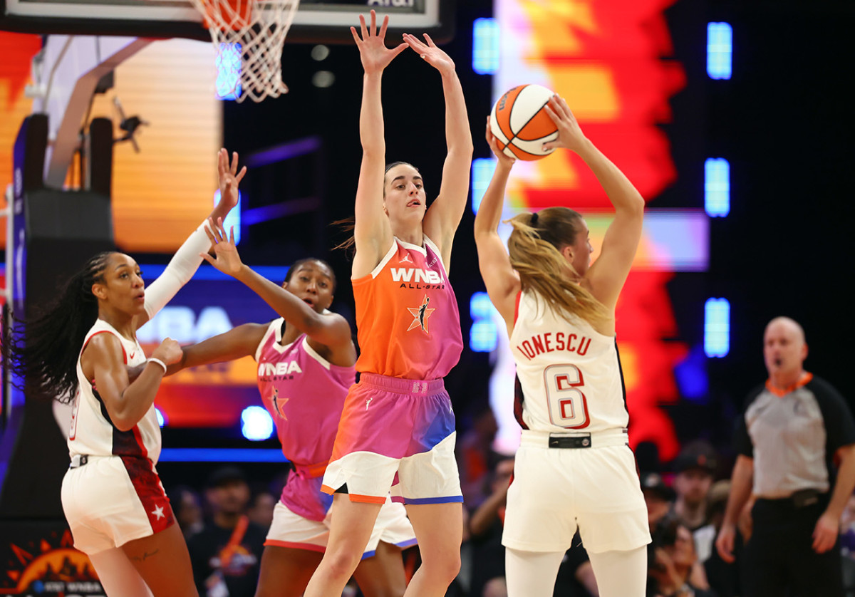 Jul 20, 2024; Phoenix, AZ, USA; Team WNBA guard Caitlin Clark (center) defends against USA Women's National Team guard Sabrina Ionescu (6) during the 2024 WNBA All Star Game at Footprint Center.