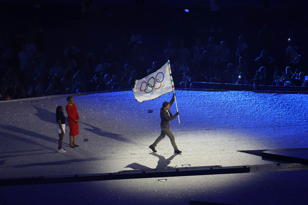 Gold medalist Simone Biles and Los Angeles Mayor Karen Bass hand the Olympic flag off to Tom Cruise during the closing ceremony for the Paris 2024 Olympic Summer Games at Stade de France.