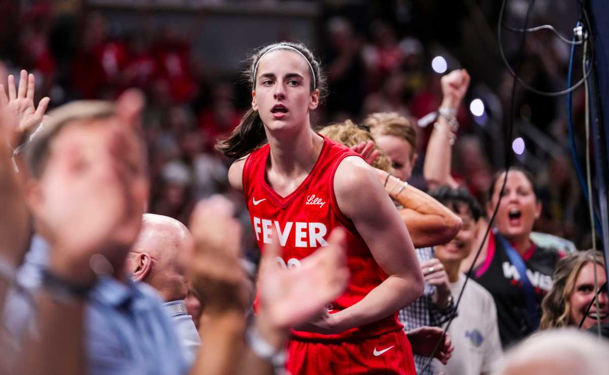 Indiana Fever guard Caitlin Clark (22) celebrates with fans behind the basket during the game at Gainbridge Fieldhouse in Indianapolis.