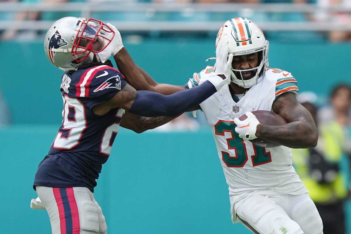 Miami Dolphins running back Raheem Mostert (31) stiff-arms New England Patriots cornerback J.C. Jackson (29) during the second half of an NFL game