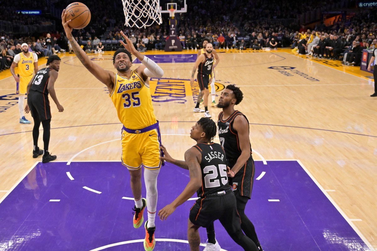 Los Angeles, California, USA; Los Angeles Lakers forward Christian Wood (35) drives past Detroit Pistons guard Marcus Sasser (25) and guard Troy Brown, Jr. in the first half at Crypto.com Arena - Jayne Kamin-Oncea-Imagn Images