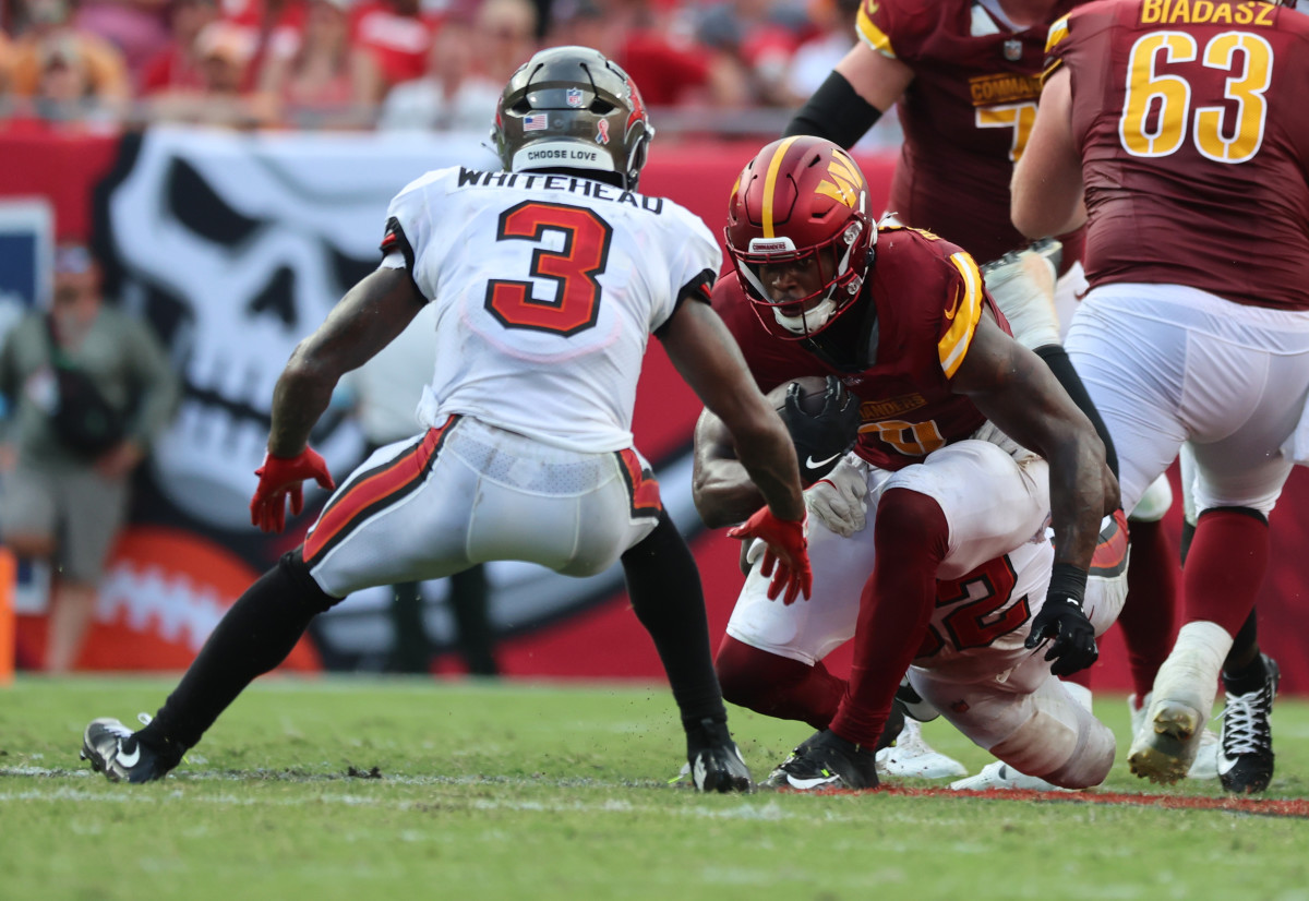 Sep 8, 2024; Tampa, Florida, USA; Washington Commanders running back Brian Robinson Jr. (8) runs with the ball as Tampa Bay Buccaneers safety Jordan Whitehead (3) defends during the second half at Raymond James Stadium.