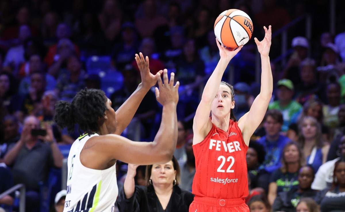 Indiana Fever guard Caitlin Clark (22) shoots over Dallas Wings center Teaira McCowan (15).