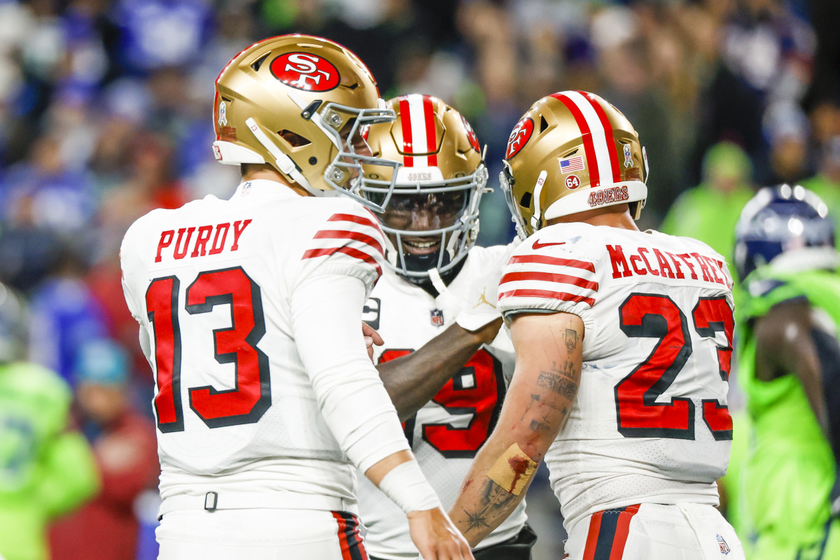 Nov 23, 2023; Seattle, Washington, USA; San Francisco 49ers running back Christian McCaffrey (23) celebrates with quarterback Brock Purdy (13) and wide receiver Deebo Samuel (19) after catching a touchdown pass from Purdy against the Seattle Seahawks during the second quarter at Lumen Field.