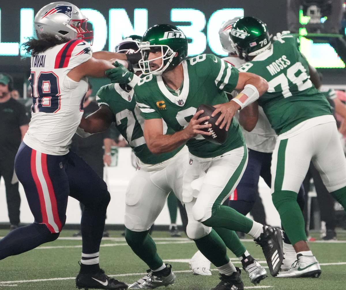 Sep 19, 2024; East Rutherford, New Jersey, USA; New York Jets quarterback Aaron Rodgers (8) takes off against New England Patriots in the first quarter at MetLife Stadium.