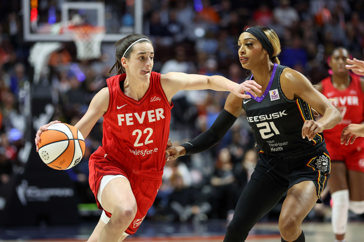 Indiana Fever guard Caitlin Clark (22) drives to the basket defended by Connecticut Sun guard DiJonai Carrington (21).