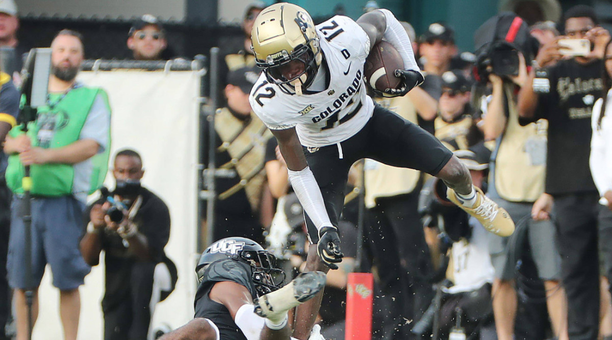 Colorado receiver Travis Hunter (12) leaps over UCF defensive back Antione Jackson at FBC Mortgage Stadium on Saturday, Sept. 28, 2024, in Orlando, Florida