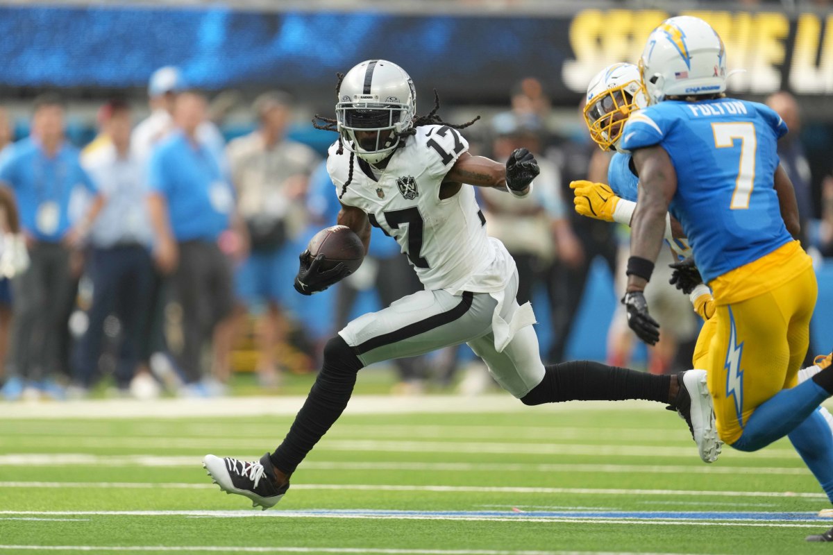 Sep 8, 2024; Inglewood, California, USA; Las Vegas Raiders wide receiver Davante Adams (17) carries the ball against Los Angeles Chargers cornerback Kristian Fulton (7) and linebacker Daiyan Henley (0) in the second half at SoFi Stadium. Mandatory Credit: Kirby Lee-Imagn Images