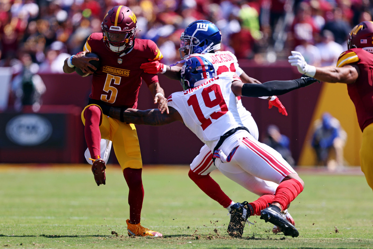 Sep 15, 2024; Landover, Maryland, USA; Washington Commanders quarterback Jayden Daniels (5) runs the ball against New York Giants linebacker Isaiah Simmons (19) during the first quarter at Commanders Field