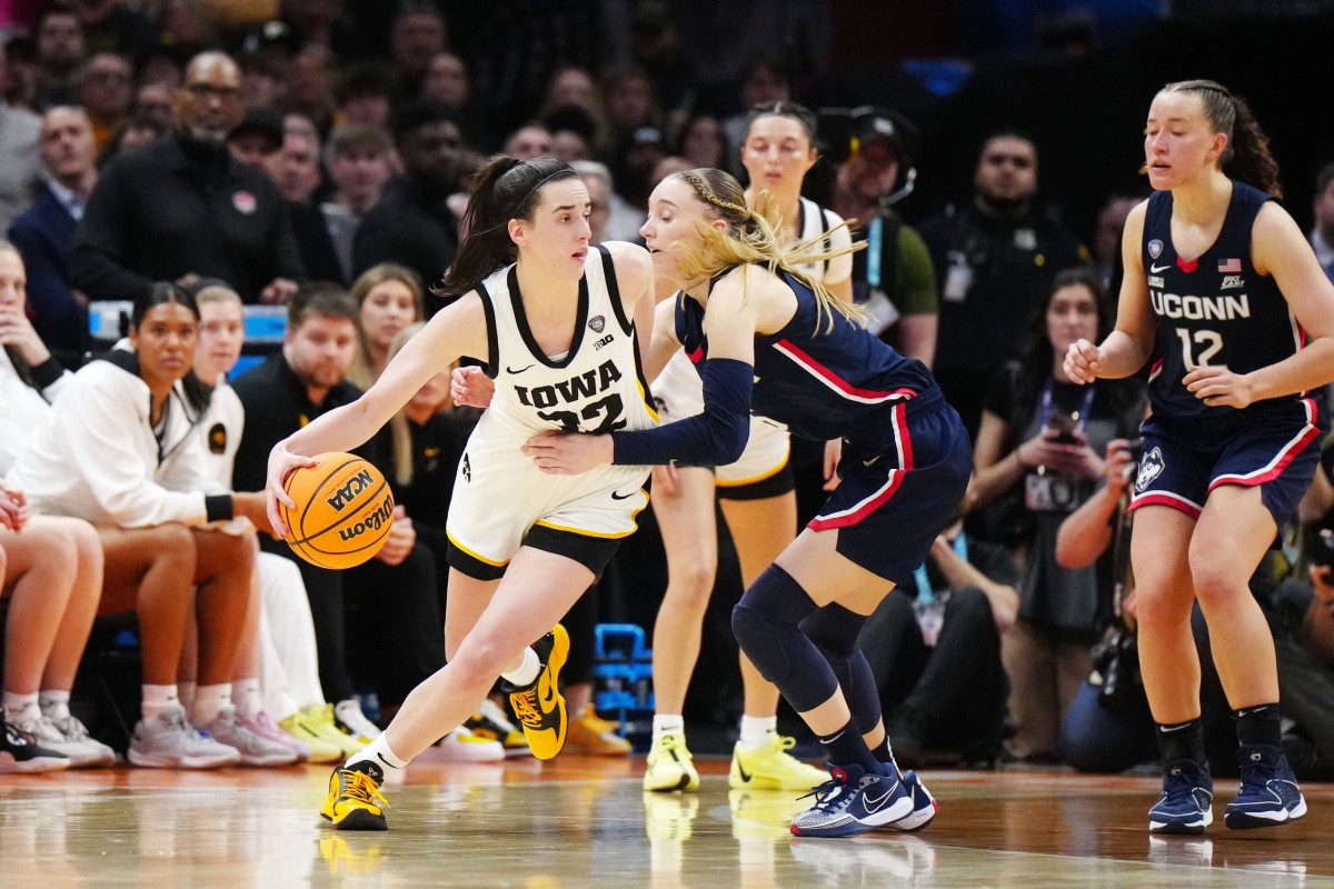Former Iowa Hawkeyes guard Caitlin Clark controls the ball against Connecticut Huskies guard Paige Bueckers.