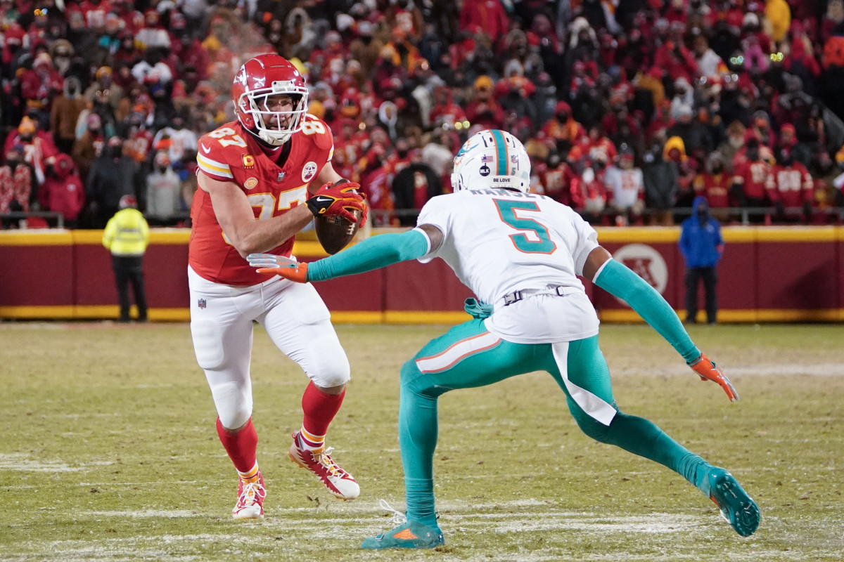 Kansas City Chiefs tight end Travis Kelce (87) runs the ball as Miami Dolphins cornerback Jalen Ramsey (5) defends in a 2024 AFC wild card game at GEHA Field at Arrowhead Stadium.