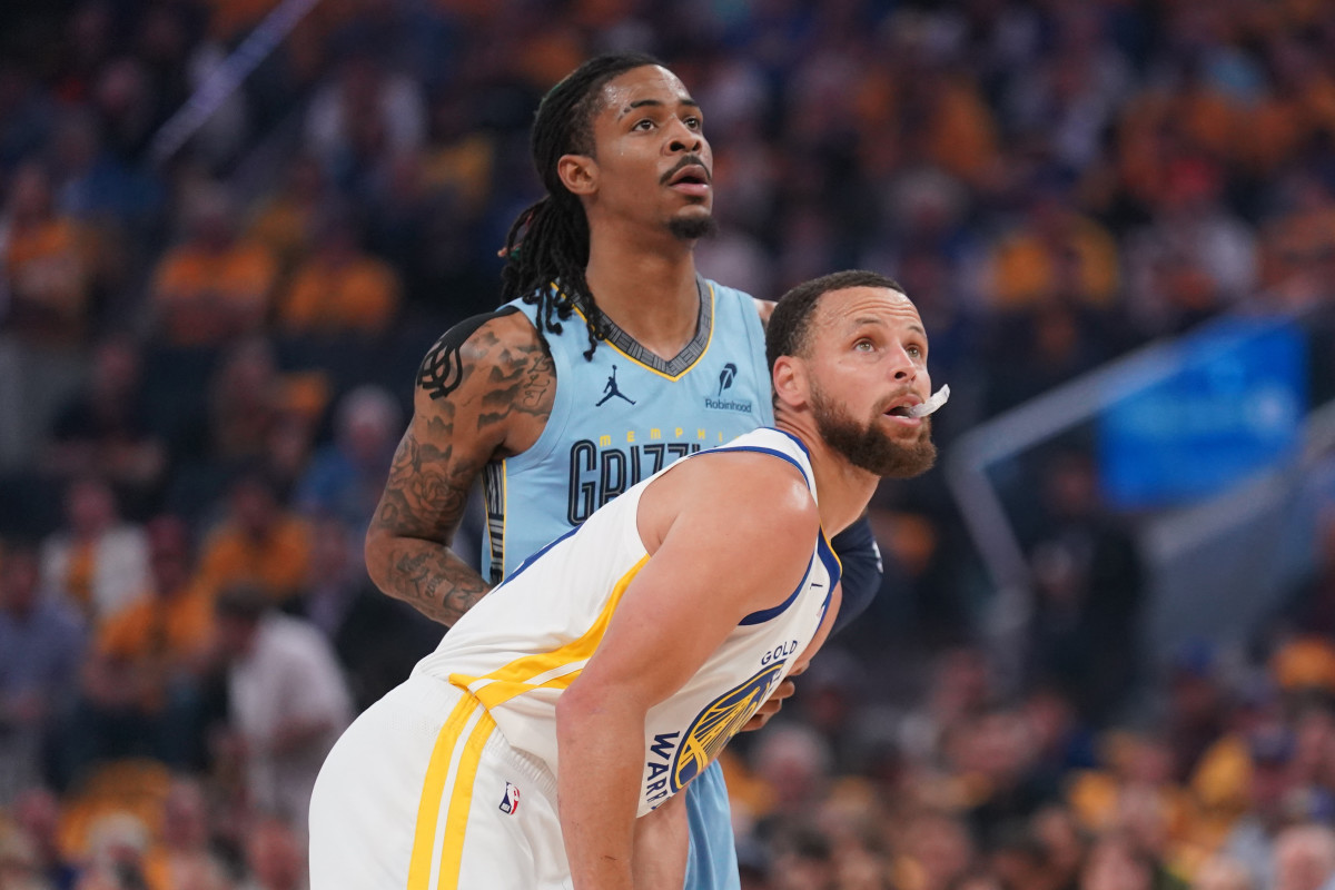 Golden State Warriors guard Stephen Curry stands in front of Memphis Grizzlies guard Ja Morant.
