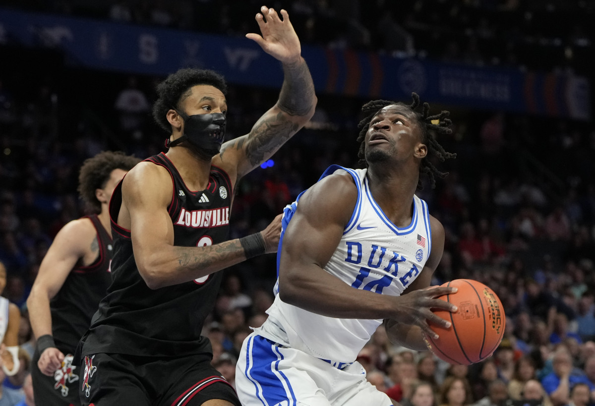 Duke Blue Devils guard Sion James (14) shoots against Louisville Cardinals forward James Scott (0).