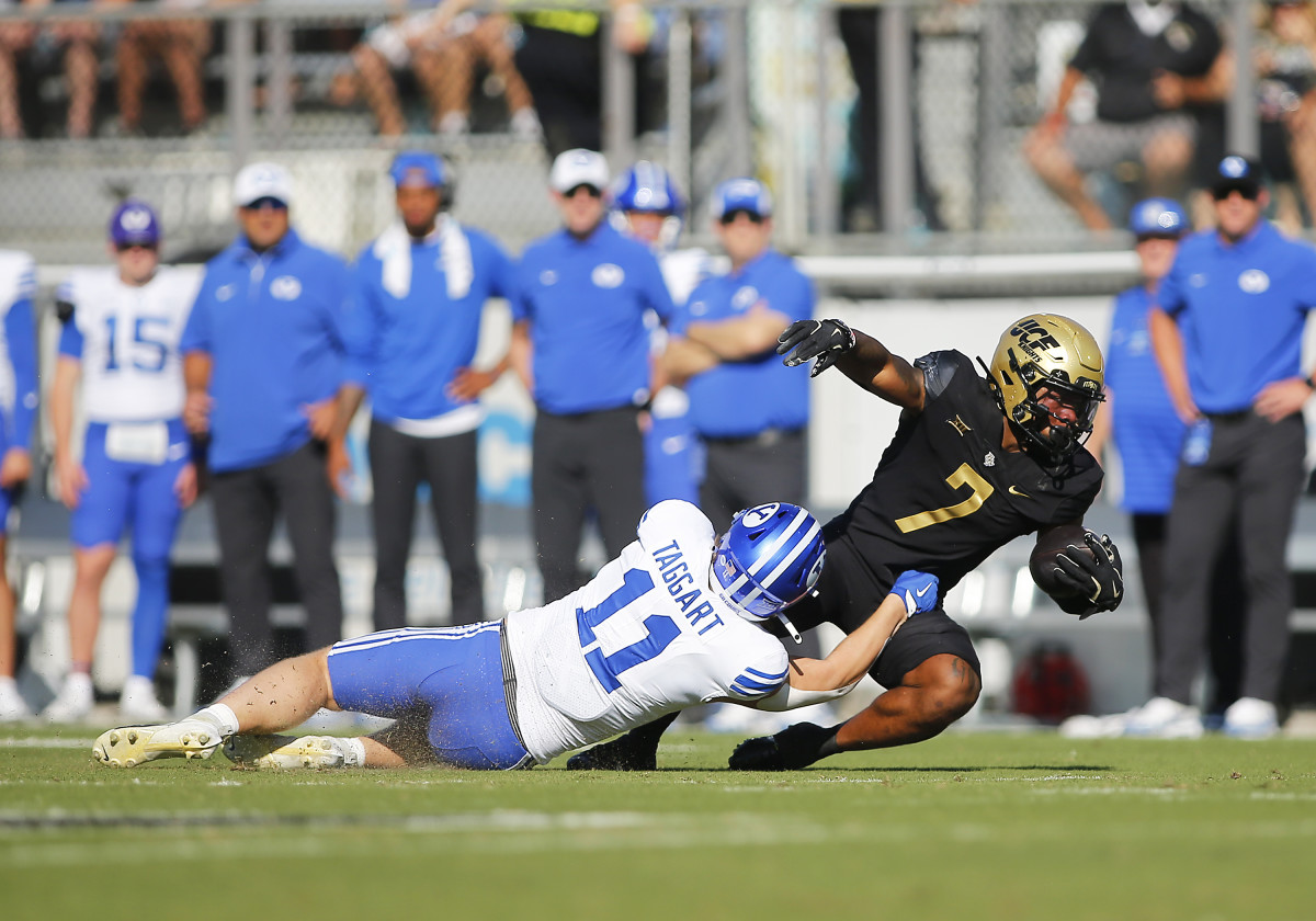 UCF Knights running back RJ Harvey (7) is tackled by BYU linebacker Harrison Taggart (11).