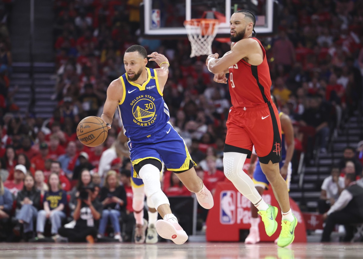 Golden State Warriors guard Stephen Curry (30) controls the ball as Houston Rockets forward Dillon Brooks (9) defends during the second quarter at Toyota Center.