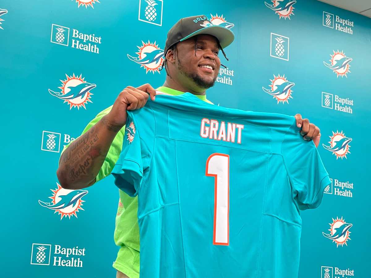 Miami Dolphins first-round pick Kenneth Grant holding up his jersey (1) at his post-draft press conference on Friday, April 25, 2025, in Miami Gardens.