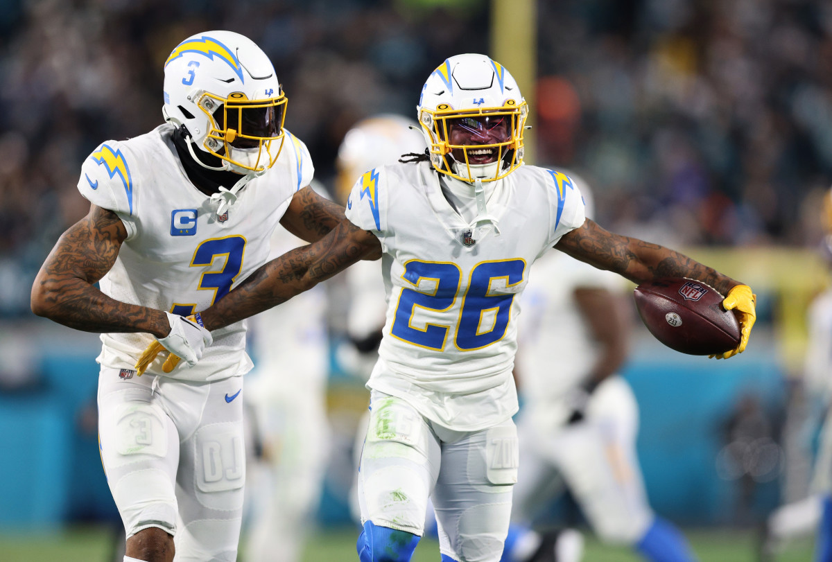 Jan 14, 2023; Jacksonville, Florida, USA; Los Angeles Chargers cornerback Asante Samuel Jr. (26) celebrates with safety Derwin James Jr. (3) after an interception during the second quarter of a wild card game against the Jacksonville Jaguars at TIAA Bank Field. Mandatory Credit: Nathan Ray Seebeck-Imagn Images