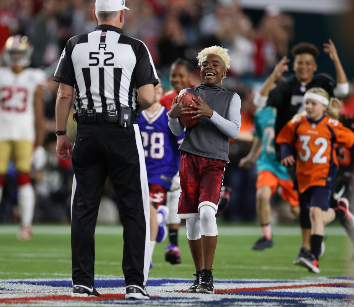 Maxwell Bunchie Young presents the game ball to referee Bill Vinovich (52) before Super Bowl LIV.
