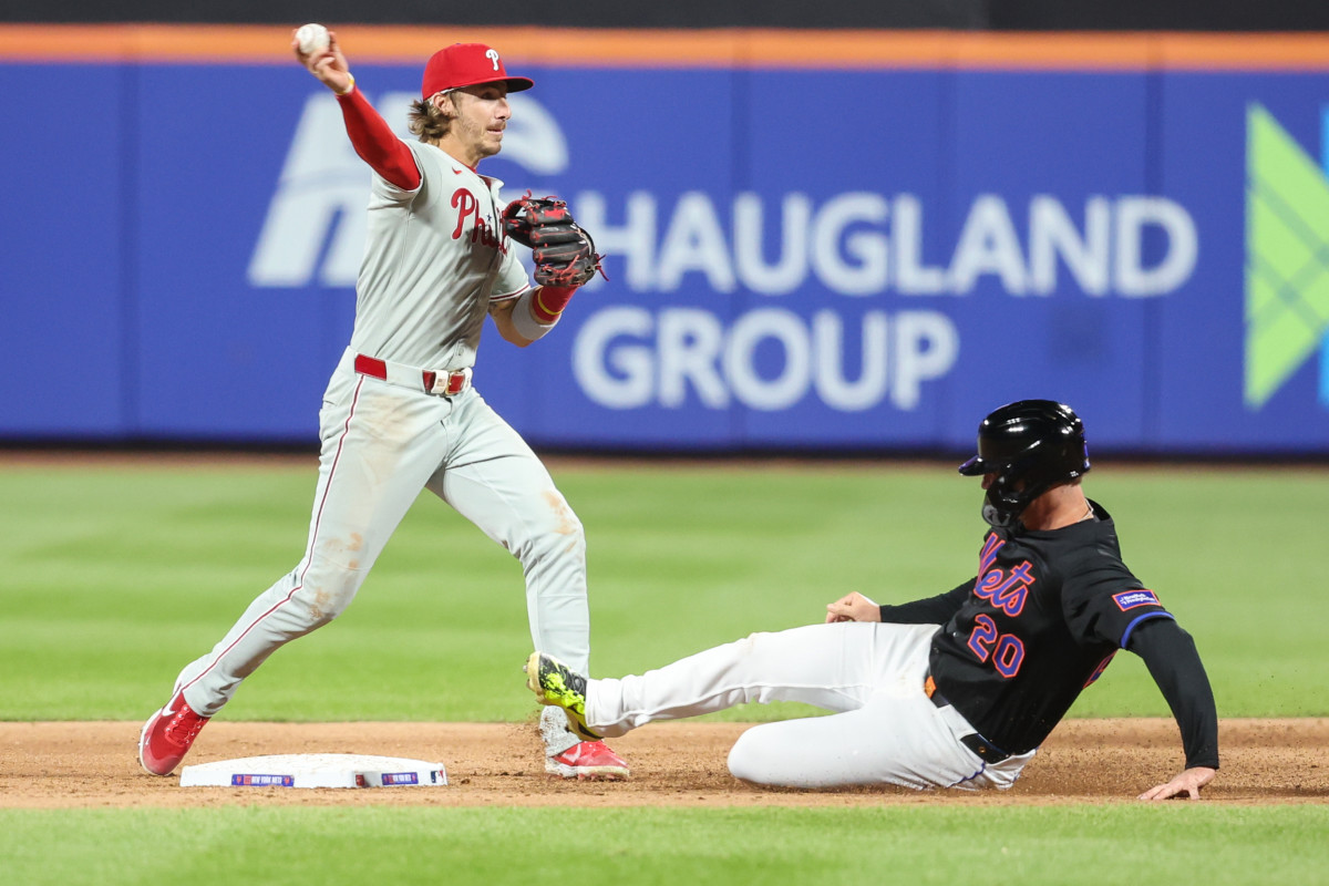 Philadelphia Phillies second baseman Bryson Stott (5) throws past New York Mets first baseman Pete Alonso (20) in the third inning at Citi Field.