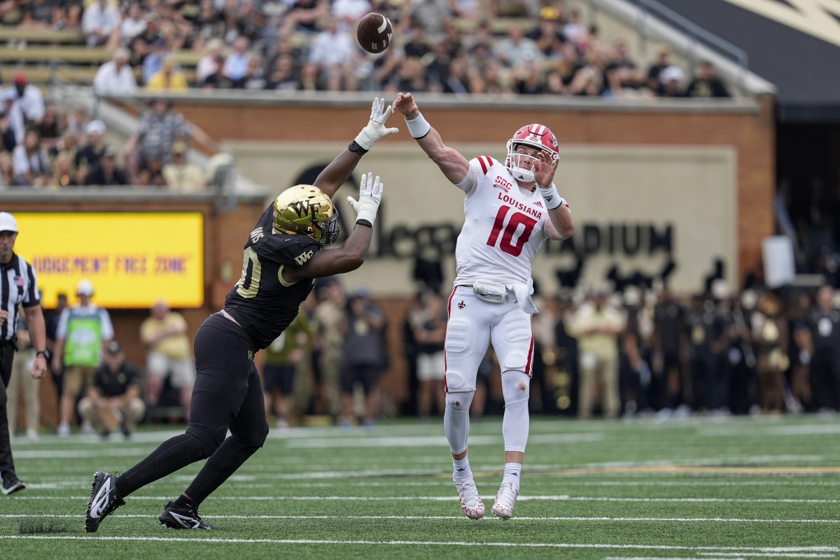 Louisiana-Lafayette Ragin Cajuns quarterback Ben Wooldridge (10) throws under pressure from Wake Forest Demon Deacons defensive lineman Jasheen Davis (30). Mandatory Credit: Jim Dedmon-Imagn Images