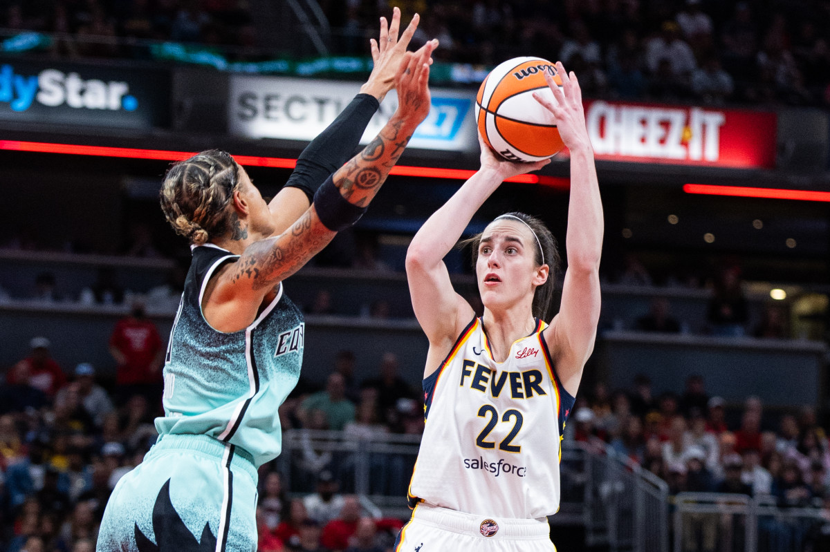 Caitlin Clark shoots over Natasha Cloud.