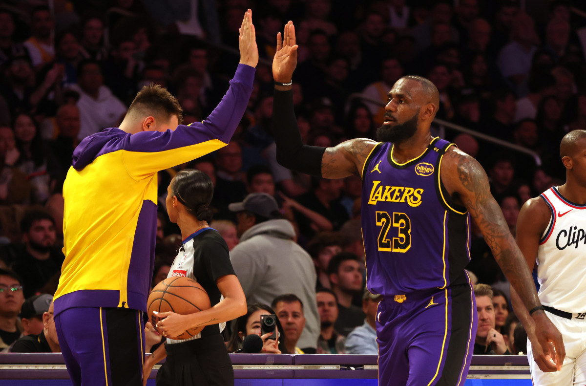 Feb 28, 2025; Los Angeles, California, USA; Los Angeles Lakers forward LeBron James (23) celebrates with guard Luka Doncic (77) during the second quarter against the LA Clippers at Crypto.com Arena. Mandatory Credit: Jason Parkhurst-Imagn Images